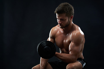 Fototapeta na wymiar Studio shot of a fit muscular young man exercising with dumbbell shirtless on black background copyspace fitness gym sport sportsman athlete sexy hot body care health motivation effort achievement.