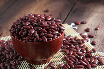 Red beans in a cup with a wooden sign on the wooden floor.