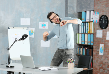 Handsome man listening to music at workplace