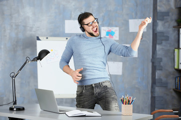 Handsome man listening to music at workplace