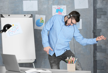 Handsome man listening to music at workplace