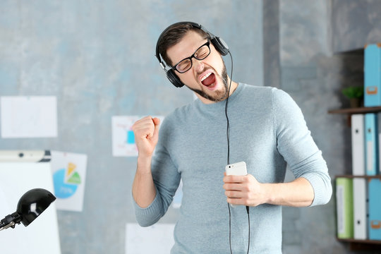 Handsome man listening to music at workplace