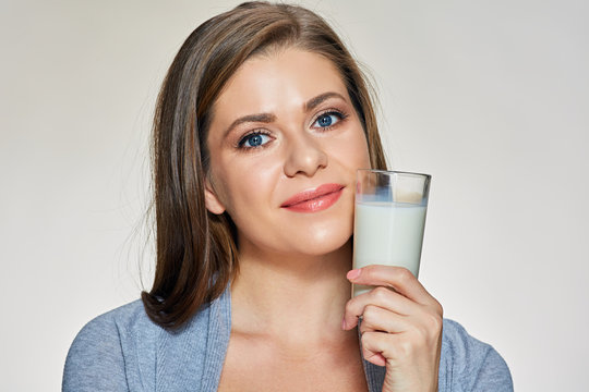 Close up face portrait of young woman holding milk glass.