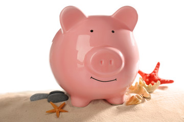Composition with piggy bank on sand. Travel savings concept