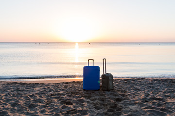 Travel, holiday and vacation concept - two suitcases on the beach.