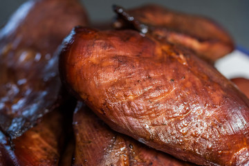 Freshly hot smoked chicken breasts or fillets piled on a plate.