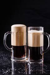 Two mugs of frothy beer
