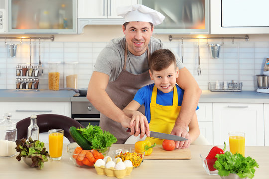 Father and son cooking together in kitchen