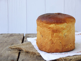 Easter sweet bread, paska on light wooden background. Orthodox kulich. Holidays breakfast concept with space for text.