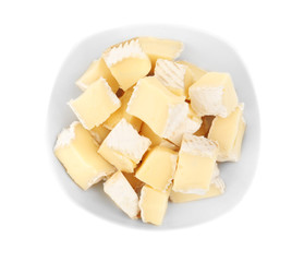 Delicious pieces of cheese in bowl on white background