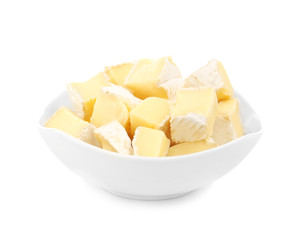 Delicious pieces of cheese in bowl on white background