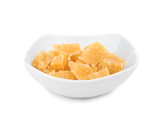 Delicious pieces of cheese in bowl on white background