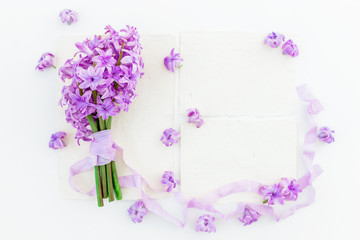 Bouquet of hyacinth flowers, petals, paper cards and tapes on white background. Flat lay, top view.