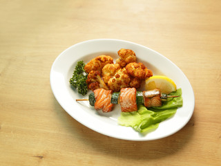 grilled salmon with garnish on white plate in restaurant