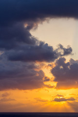 Fototapeta premium Silent morning at the sea. Dramatic sky with sun rays coming behind the clouds on a beautiful morning. Sunrise at Caribbean sea.
