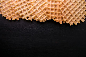 Belgian waffles on black background. Top view. Copy space. Frame.
