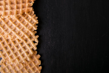 Belgian waffles on black background. Top view. Copy space. Frame.
