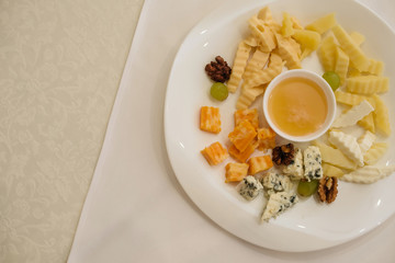 Mix cheese on wooden board with grapes. Top view.