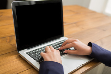 Business woman using laptop at workplace, close-up