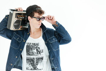 Handsome young man holding boombox. Looking aside.