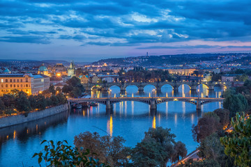 Obraz premium View on bridges across Vltava river at dusk from Letenske sady in Parague, Czech republic