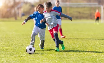 Fotobehang Kids soccer football - children players match on soccer field © Dusan Kostic