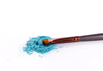 Makeup brush background with eyeshadow sprinkled on white
