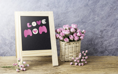 Mothers day concept of paper pink rose flowers with love mom on black board