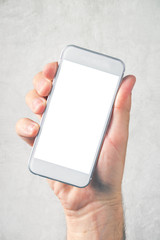 Male hand holding mobile phone with blank mock up screen