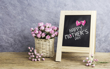 Happy mothers day message on black board and paper pink rose flowers in basket