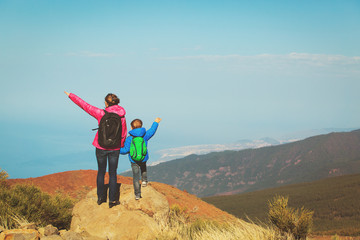 family travel- mother and son hiking in mountains