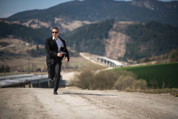 Agent in a suit holding a gun and running at a highway construction site in James Bond movie style.