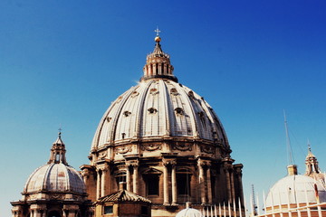Fototapeta na wymiar Cupola of St Peters Basilica in the Vatican, Rome, Italy against blue sky