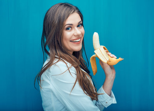 Portrait of beautiful smiling girl holding banana.