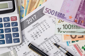 different euro bills with 2017 calendar and pen.