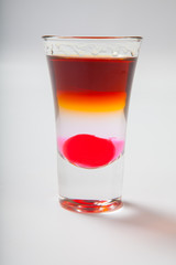 Alcoholic cocktail in shot glass isolated on white