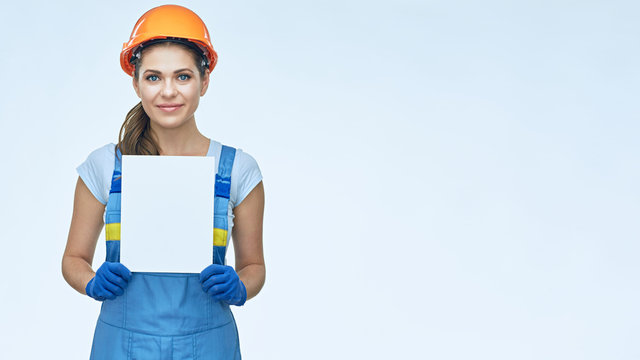 Smiling woman builder holding white baneer.