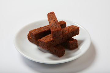 Roasted garlic croutons, black bread on a white plate.