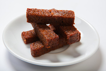 Roasted garlic croutons, black bread on a white plate.