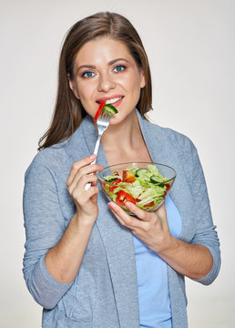 Woman eating salad. Smiling female model with long hair.