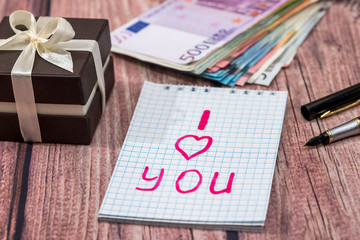 text i love you with gold earrings, money on desk.