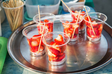 strawberry in plastic cups at street market