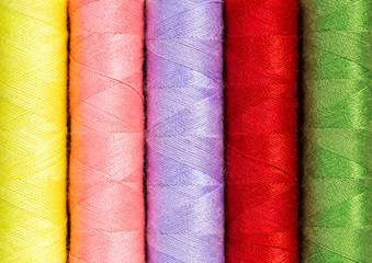 Close up colorful thread spools used in fabric and textile industry