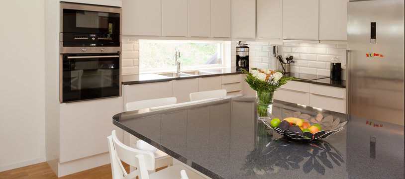 horizontal banner of a fancy kitchen with a kitchen island  in the foreground