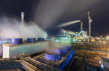Fototapeta na wymiar Chemical plant for production of ammonia and nitrogen fertilization on night time. Large cooling towers with steam next to the pipeline