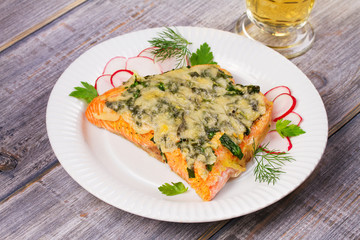 Baked salmon with spinach and cheese. Fish on white plate.