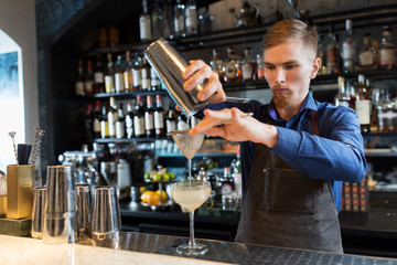 Fototapeta na wymiar barman with shaker preparing cocktail at bar