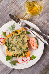 Baked salmon with spinach and cheese. Fish on white plate.