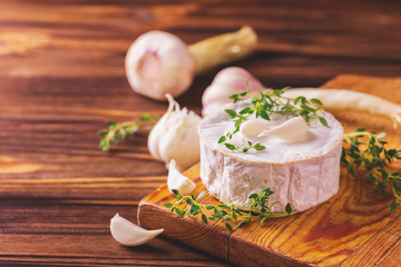 Fototapeta na wymiar French homemade Camembert cheese with thyme and garlic