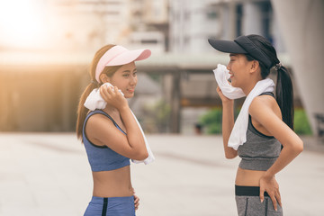 Young woman staying with a towel after workout. Fitness and healthy lifestyle concept.